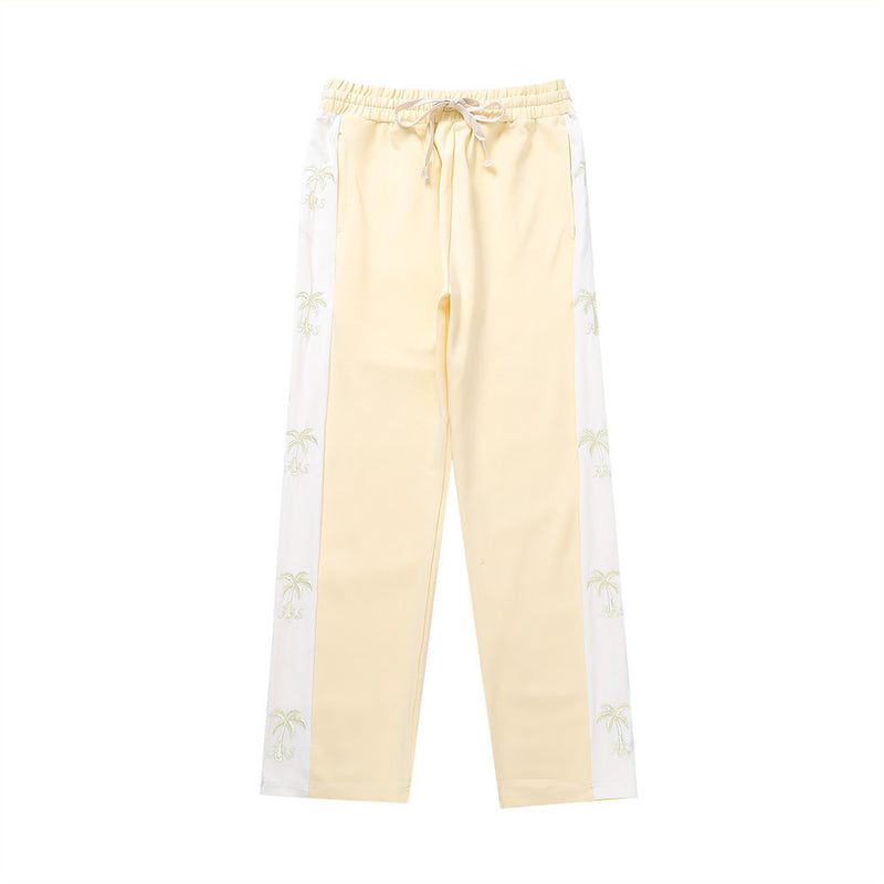 track pants, athleisure pants, casual style, streetwear, palm tree print, side stripe, relaxed fit, men's fashion, tropical design, trendy pants, comfortable fit, breathable fabric, lounging pants, versatile pants, everyday wear, island-inspired, soft fabric, stylish track pants, athletic-inspired, men’s casual pants, bold stripe, cool outfit, men’s wardrobe essential, statement pants, urban fashion