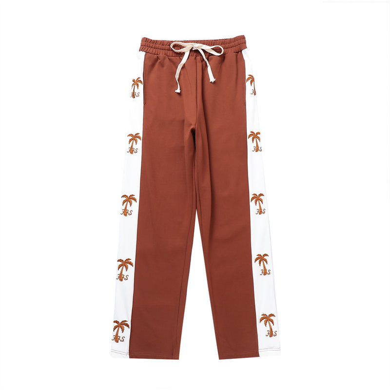 track pants, athleisure pants, casual style, streetwear, palm tree print, side stripe, relaxed fit, men's fashion, tropical design, trendy pants, comfortable fit, breathable fabric, lounging pants, versatile pants, everyday wear, island-inspired, soft fabric, stylish track pants, athletic-inspired, men’s casual pants, bold stripe, cool outfit, men’s wardrobe essential, statement pants, urban fashion